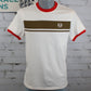 A white short-sleeve ringer T-shirt displayed on a gray mannequin torso against a white brick wall. The shirt features a red crew neck and sleeve cuffs, a wide brown horizontal chest stripe with a thin white line through the middle, and a small circular white logo on the left chest.